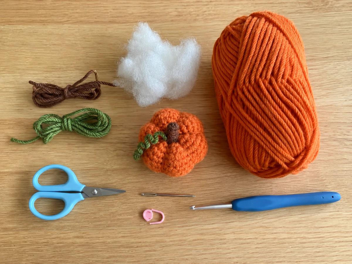 orange yarn hook stuffing and supplies for a crochet pumpkin fidget toy
